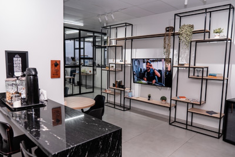 Área de convivência e copa do Enjoy Work com bancada e TV