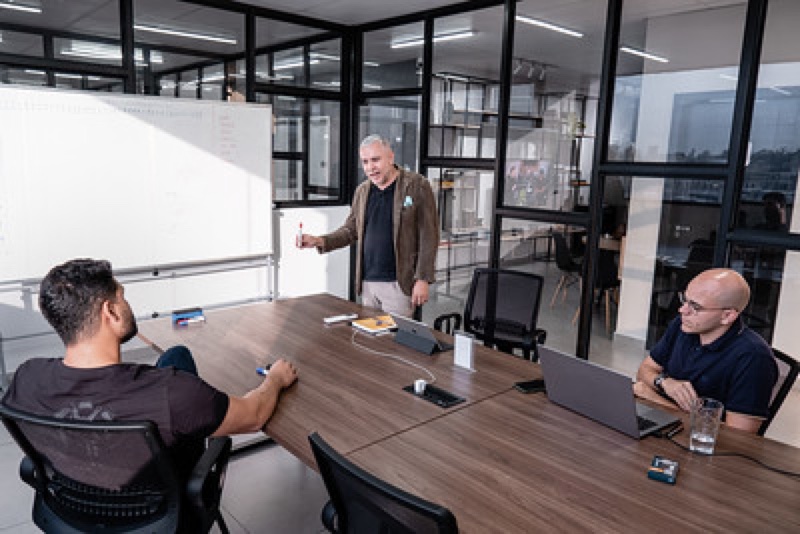 Equipe em reunião em sala do Enjoy Work com vista para a cidade